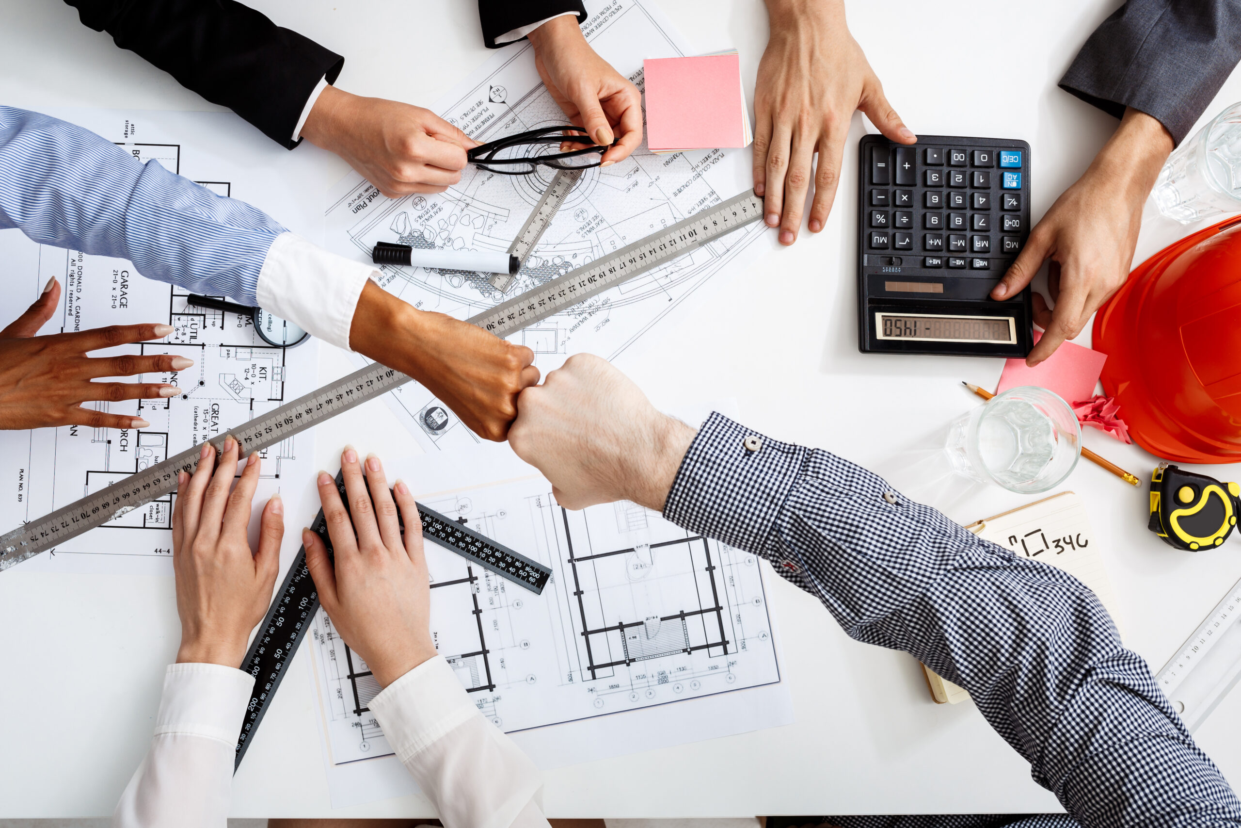 Picture of businessmen's hands on white table with documents and drafts