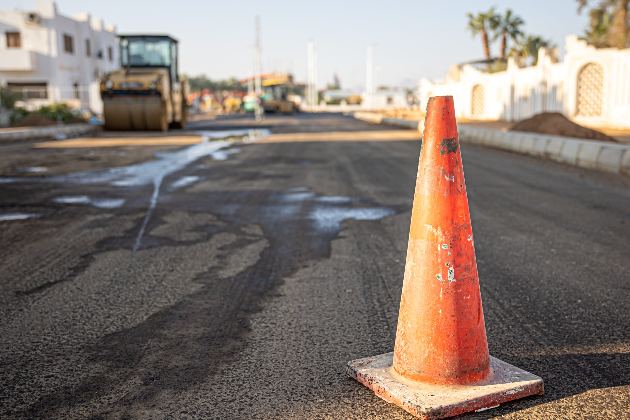 Close up of an orange traffic cone on the road.